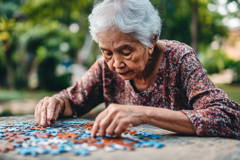 An older person working on a puzzle in the park