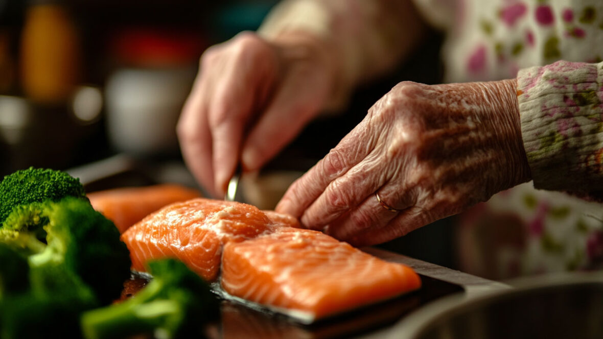 An elderly person preparing salmon for cooking