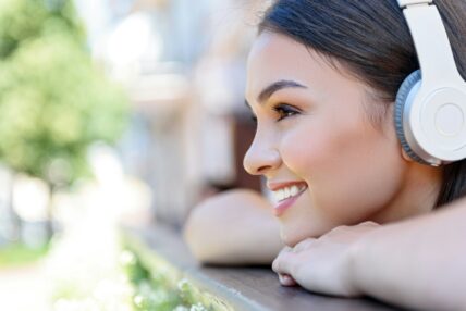 woman smiling with headphones / foods to eat for whiter teeth