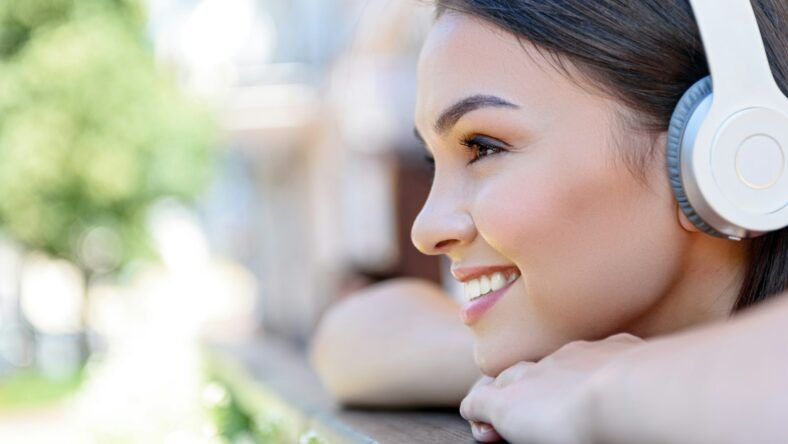 woman smiling with headphones / foods to eat for whiter teeth