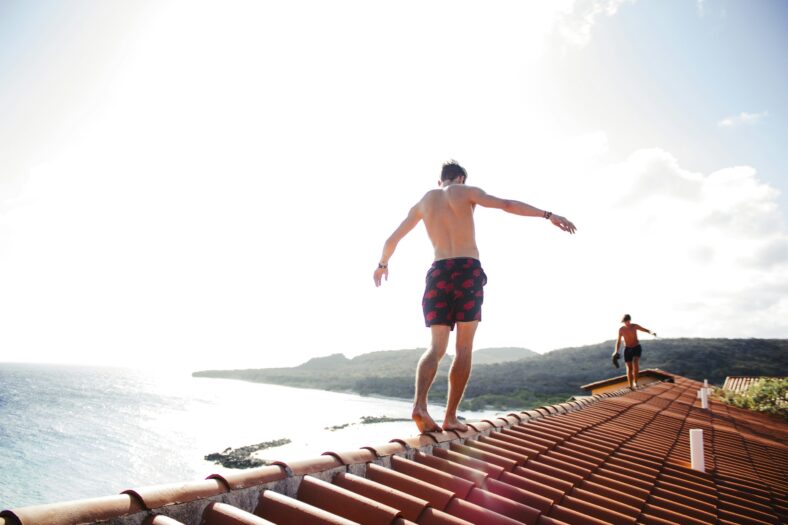 man balancing on rooftop