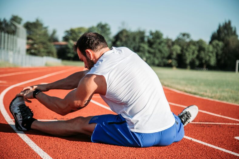 man stretching on a track
