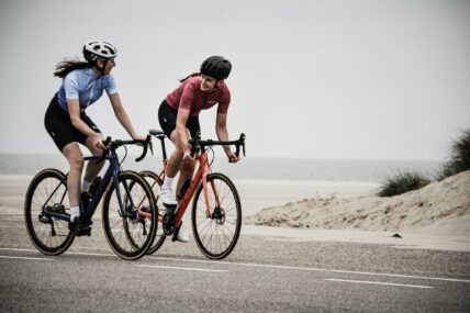 two females on bicycles / cycling