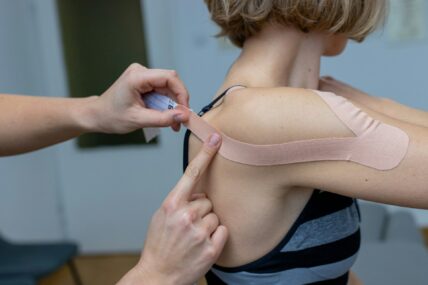 woman taping her shoulder / shoulder pain