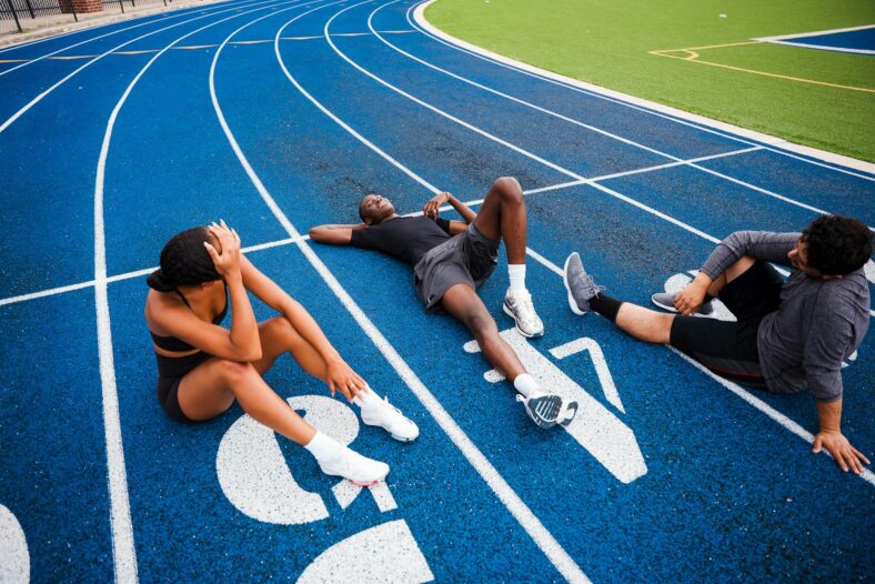 three people sitting on a track