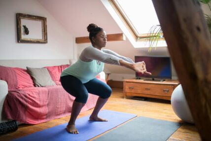 woman doing a squat on a yoga mat / squats / deadlifts