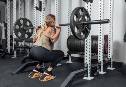 woman using squat wedges with barbell
