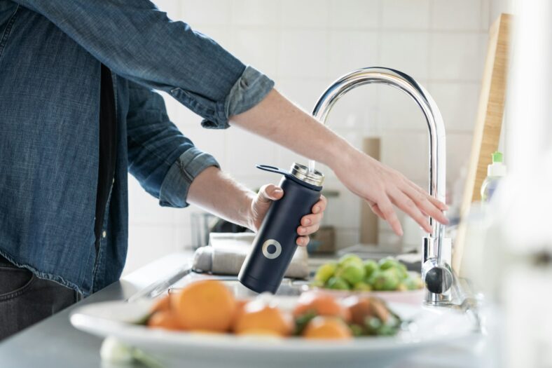 woman filling up water bottle