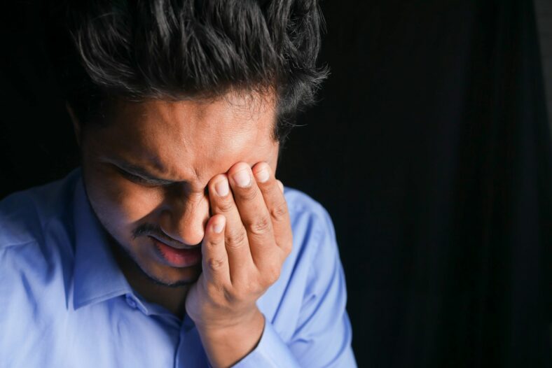 man wiping eye