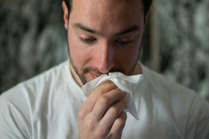 man wiping nose with tissue / signs you have allergies